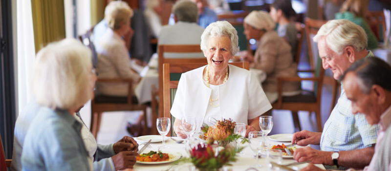Rentner am Essenstisch die gut gelaunt zusammen essen